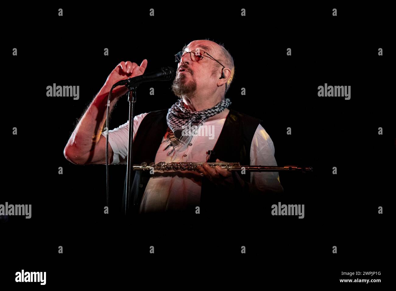 Ian Anderson is playing the flute on stage with his band Jethro Tull at