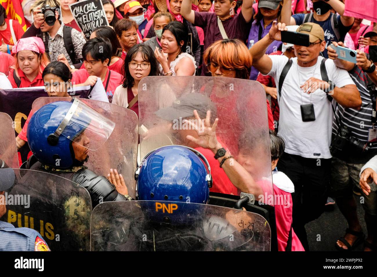 Womens groups scuffle with police while protesting on International Womens Day Members of various womens groups and progressive organizations scuffle with the police force while marching toward Mendiola Peach Arch in Manila, Philippines, 8 March 2024. The groups plan to conduct their program in Mendiola, a protest area near the Malacanang Palace but barred by riot police along Nicanor Reyes St., in Manila. The groups proceeded with the program to highlight the issues facing Filipino Women such as landlessness, low wages, and the plan of President Ferdinand Marcos Jr. to push for a Charter Chan Stock Photo