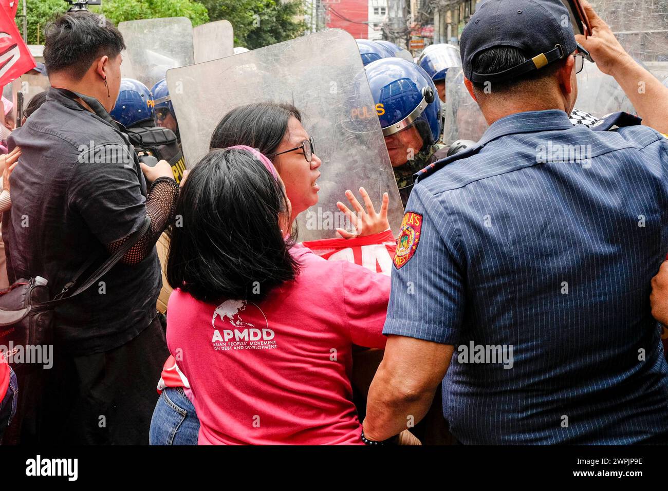 Womens groups scuffle with police while protesting on International Womens Day Members of various womens groups and progressive organizations scuffle with the police force while marching toward Mendiola Peach Arch in Manila, Philippines, 8 March 2024. The groups plan to conduct their program in Mendiola, a protest area near the Malacanang Palace but barred by riot police along Nicanor Reyes St., in Manila. The groups proceeded with the program to highlight the issues facing Filipino Women such as landlessness, low wages, and the plan of President Ferdinand Marcos Jr. to push for a Charter Chan Stock Photo