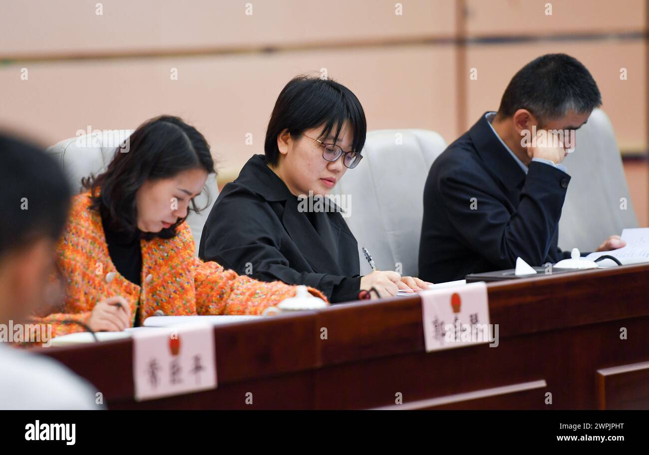 (240308) -- SHENZHEN, March 8, 2024 (Xinhua) -- Chen Shuxian (C) attends a meeting at the Municipal People's Congress of Shenzhen, south China's Guangdong Province, Feb. 26, 2024. Chen Shuxian is a technical director of the wireless software test group of Shenzhen SED Wireless Communication Technology Co., Ltd. Her office is filled with small brick-like handhelds, which are mainly used for wireless communication in rail traffic. 'I feel a sense of fulfillment every time I see the conductors of high-speed trains using the handhelds,' Chen said. After joining the company in 2008, Chen partic Stock Photo