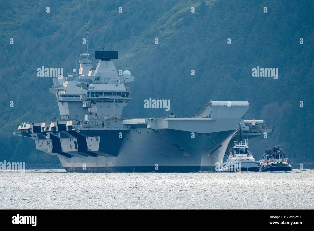 Glen Mallan, Argyll and Bute, Scotland, UK. 7th March, 2024. Royal Navy aircraft carrier HMS Queen Elizabeth arrives at Glen Mallan on Loch Long today to offload munitions prior to heading to Rosyth dockyard for repairs to her propeller couplings.  Iain Masterton/Alamy Live News Stock Photo