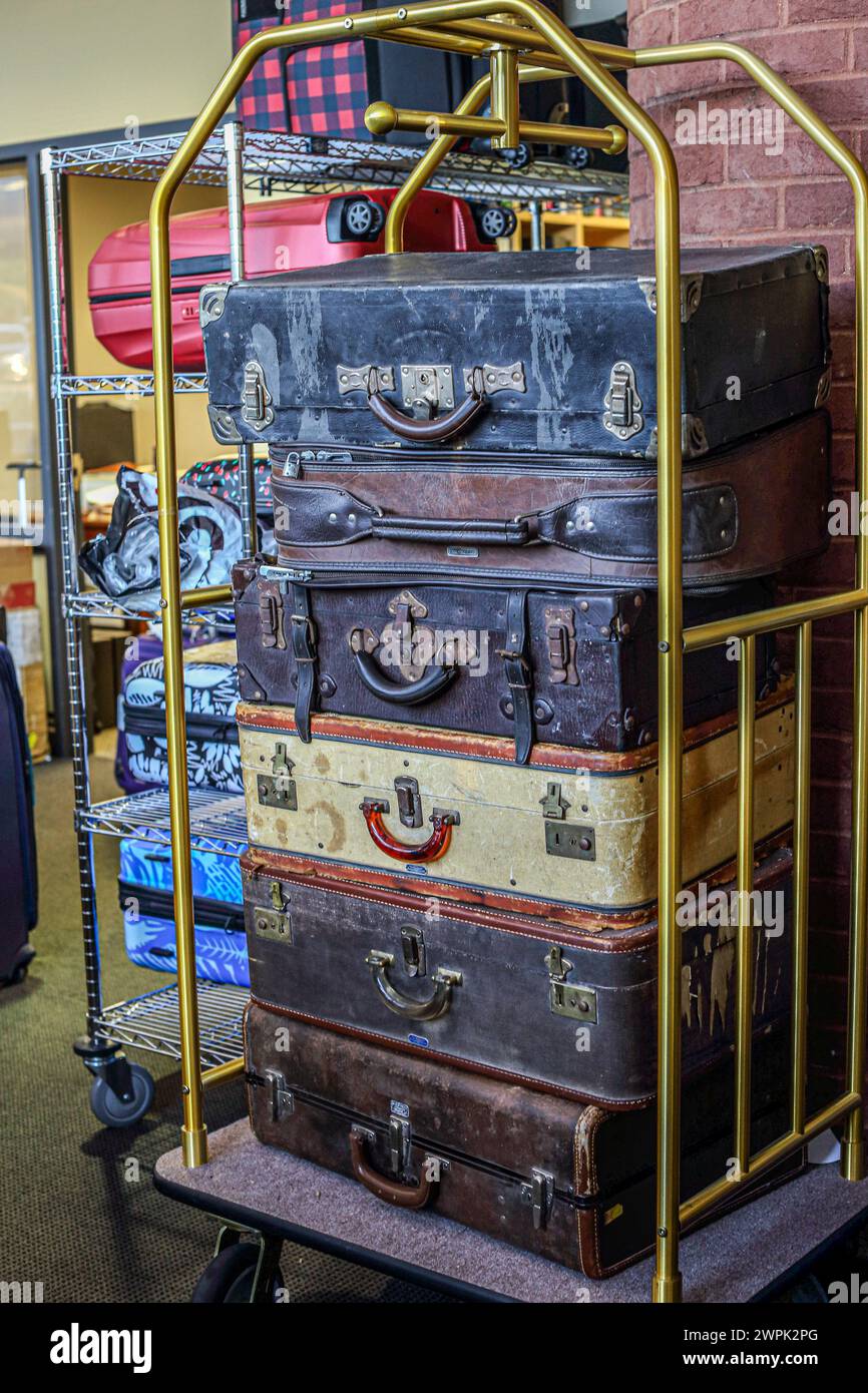 Old suitcases stacked up on trolley Stock Photo
