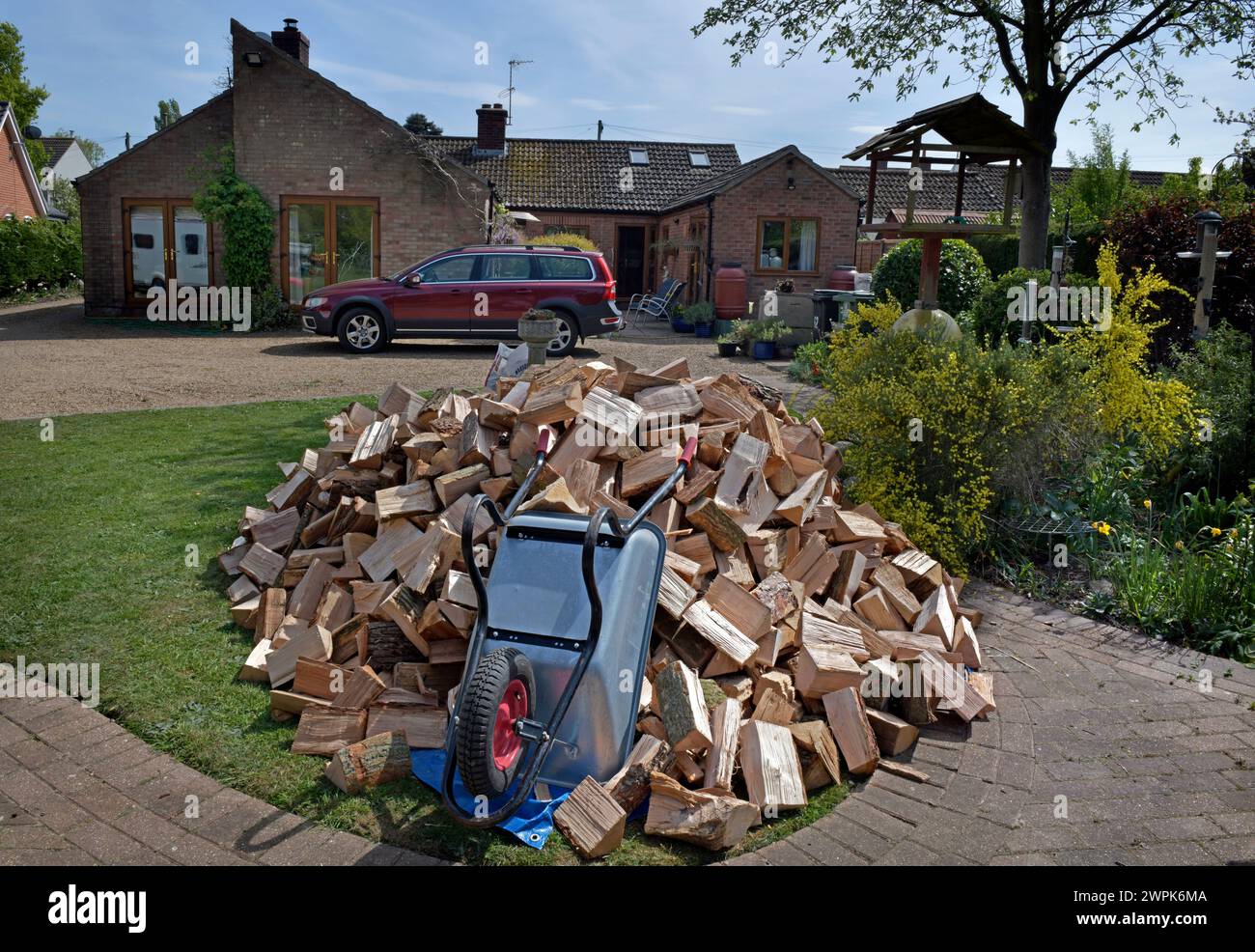 pile of firewood awaiting storage for winter in rural garden norfolk england Stock Photo