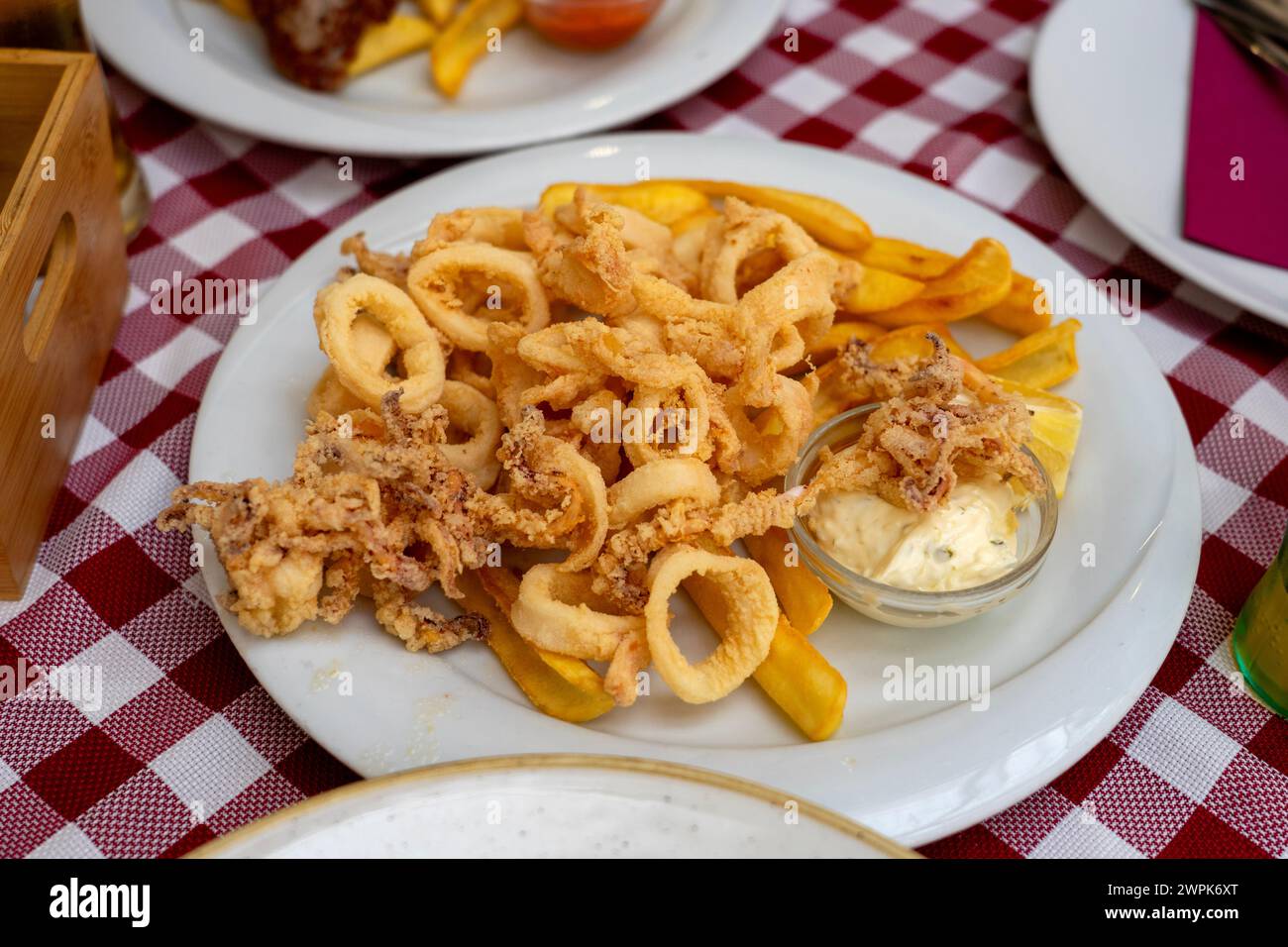 fried calamari squid fresh catch in Croatia Rovinj with garlic sauce and fries fast seafood . Stock Photo