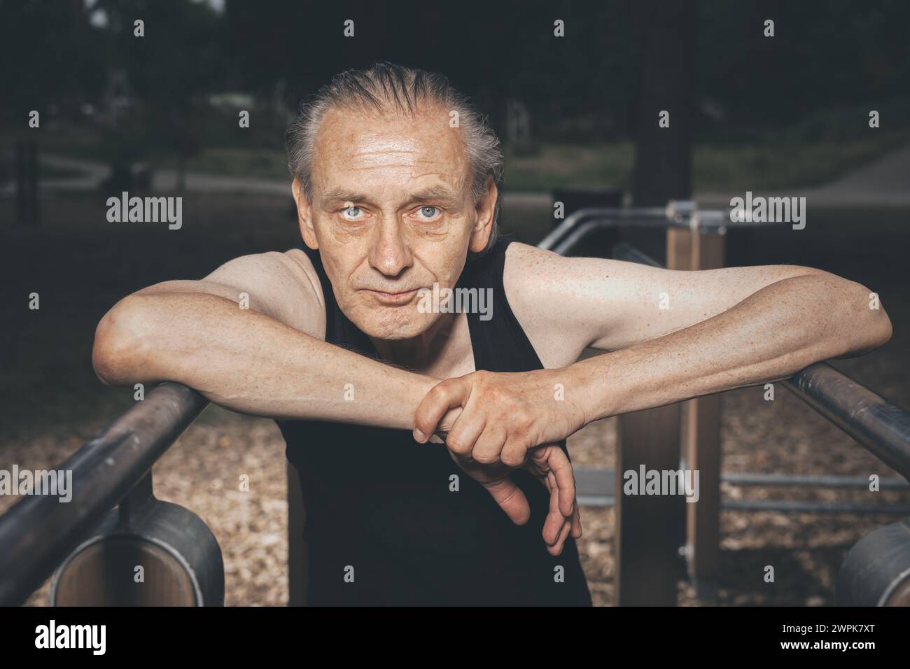 Ugly man of bad condition trying workout in outdoor gym Stock Photo