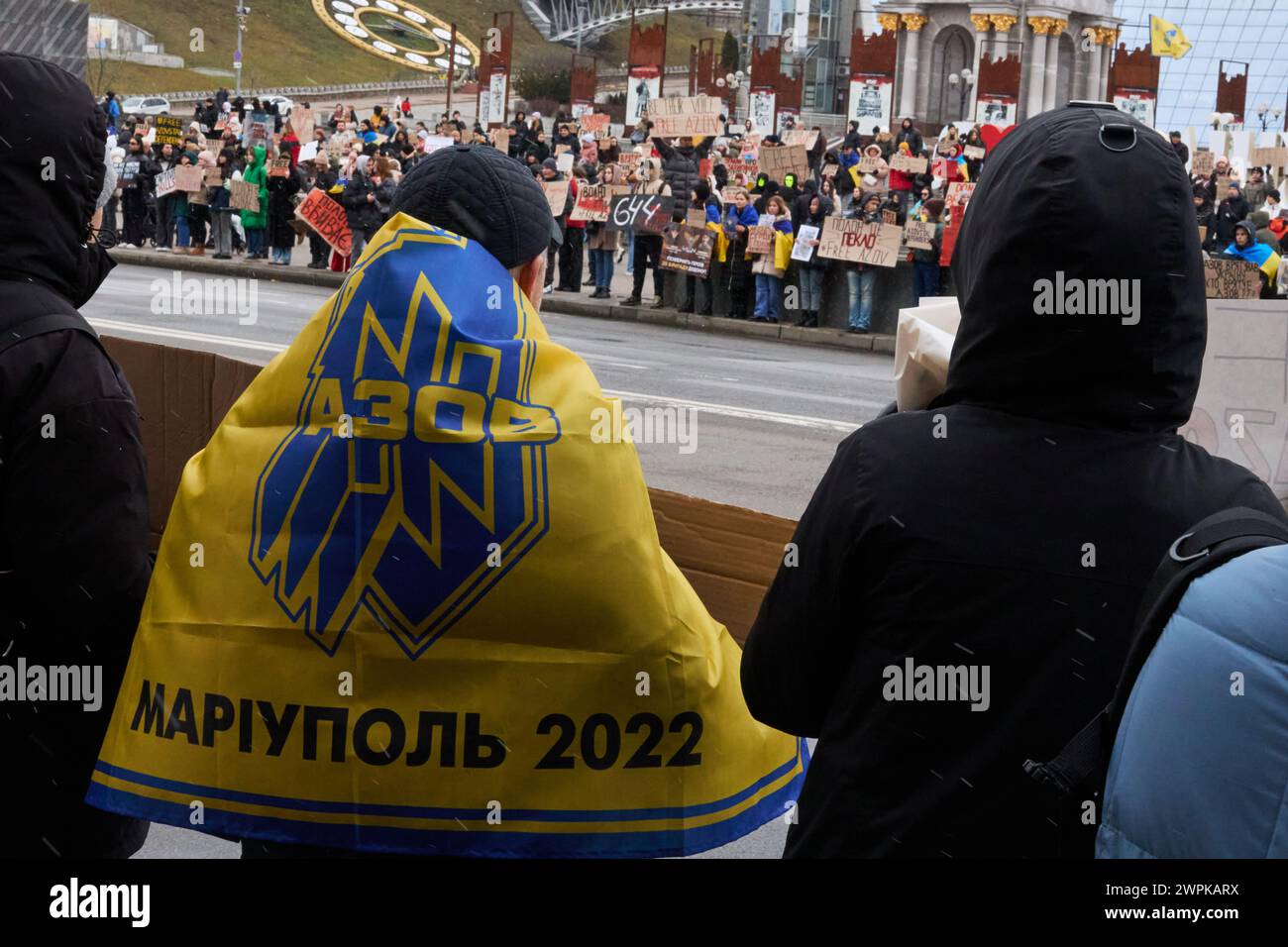 Person wearing a flag of Azov brigade from Mariupol on a public demonstration dedicated to the captured Ukrainian defenders. Kyiv - 18 February,2024 Stock Photo