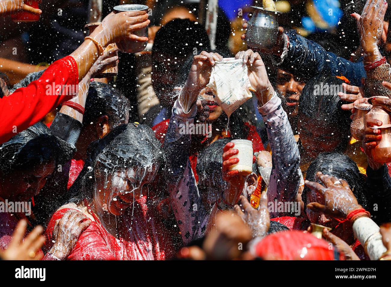 Kathmandu, Nepal. 08th Mar, 2024. Devotees chant prayers as milk is