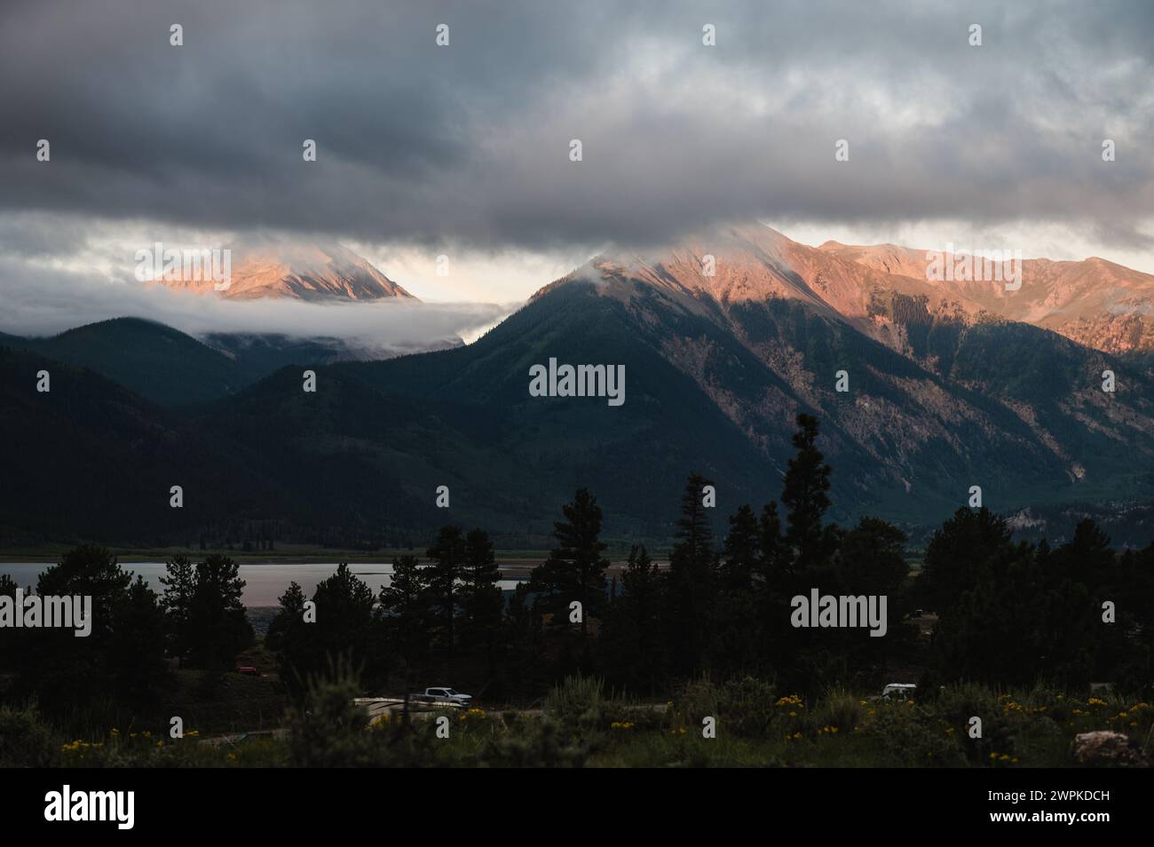 Sunlight breaks through clouds over mountain peaks. Stock Photo