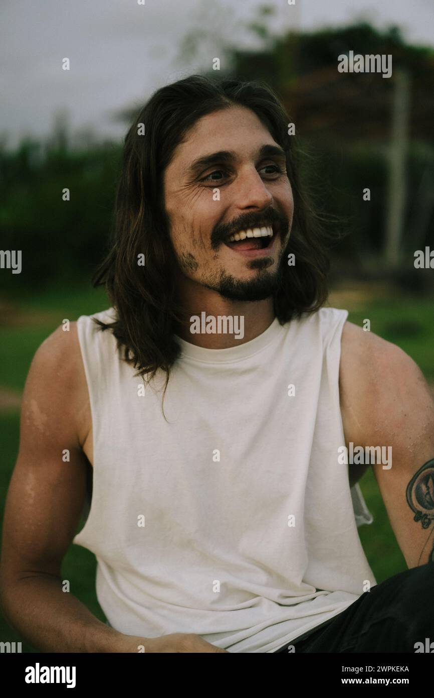 Portrait of smiling young man with long brown hair and dark eyes Stock ...