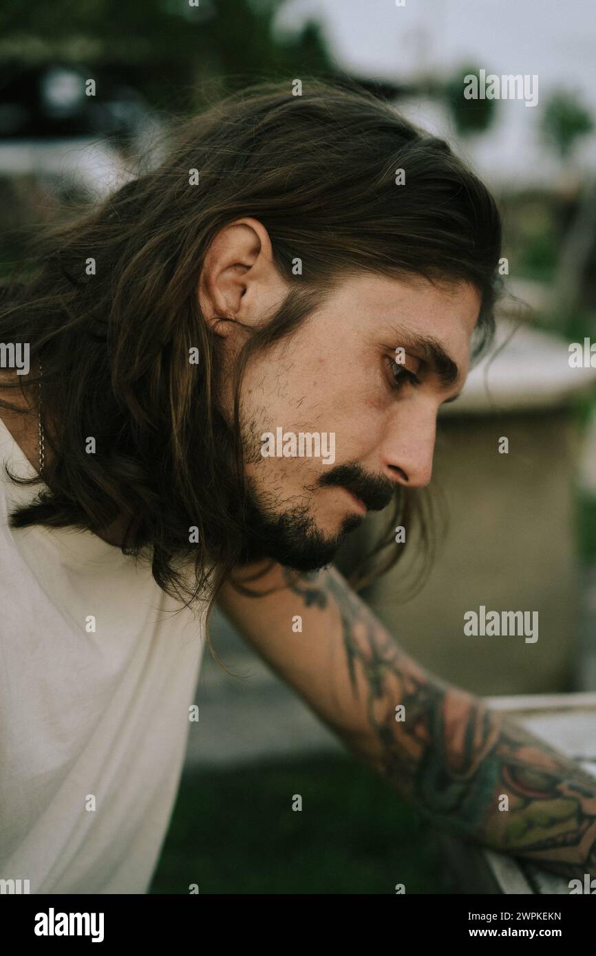 Portrait of a young man with long brown hair and dark eyes Stock Photo ...