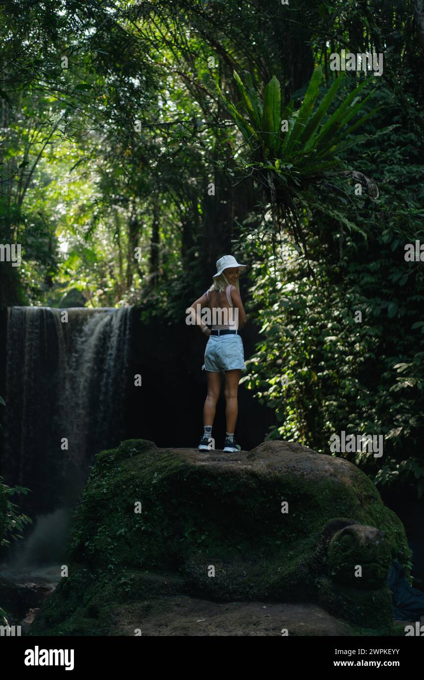 Woman traveler at Suwat waterfall in the jungle Bali. Stock Photo