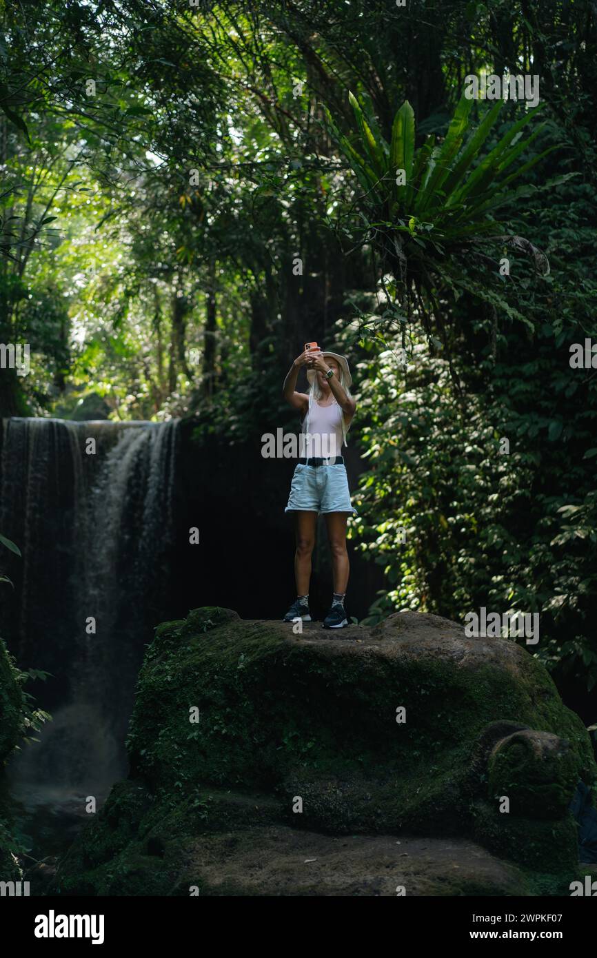 Woman traveler at Suwat waterfall in the jungle Bali. Stock Photo