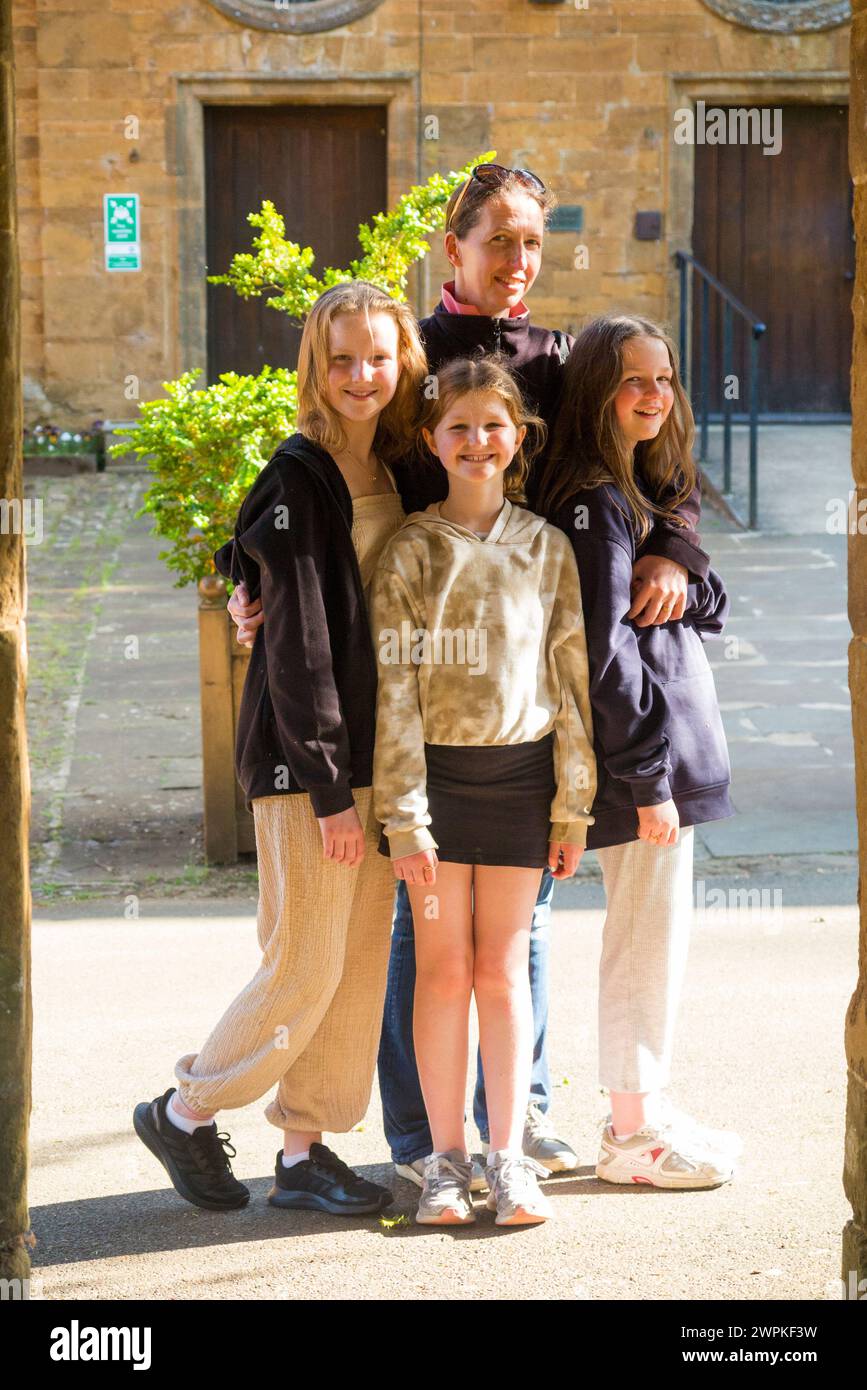 Sisters, 3 children / three kids / kid / girls pose with their mum / mother in grounds of Wroxton College / Wroxton Abbey. Oxfordshire. England. UK. (134) Stock Photo