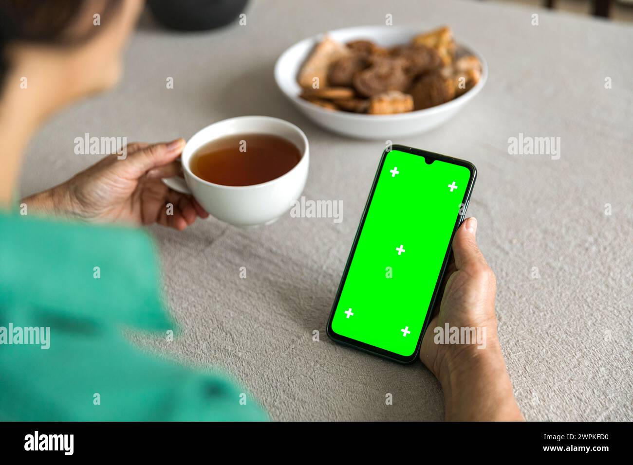 mobile phone with green screen chromakey display in elderly woman hand Stock Photo