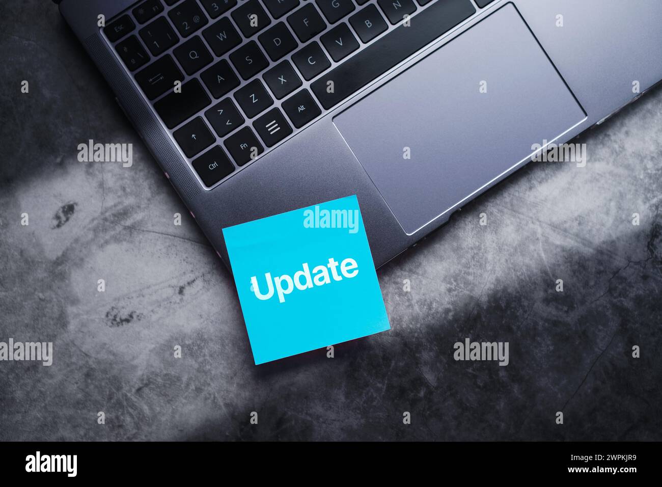 Blue post it on laptop with the word update written on it. Software upgrade concept with empty space for use. Stock Photo