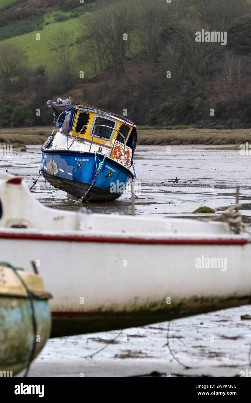 Boats moored at low tide on the tidal Gannel Estuary in Newquay in ...