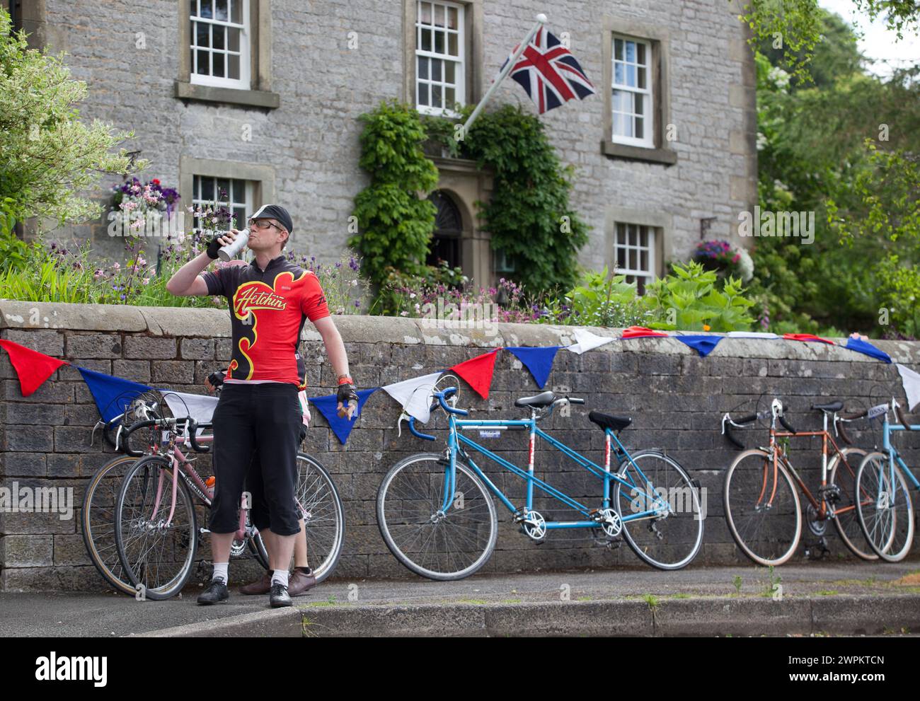 2106/15  A rider stops for a drink in Hartington.  Three Thousand cyclists riding vintage machines, all older than 1987, take to the hills of the Peak Stock Photo