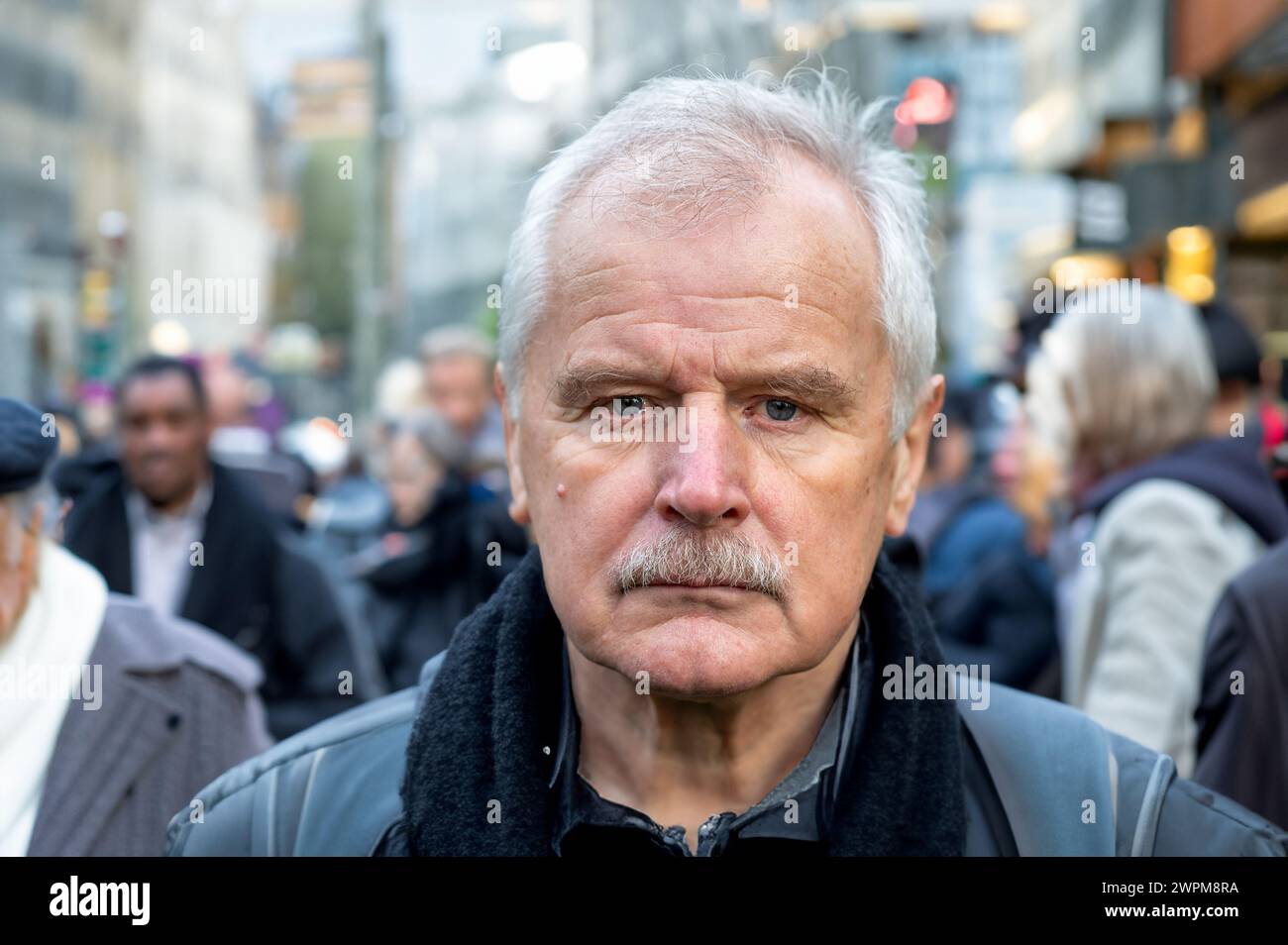 Portrait of senior citizen in a crowded street. Stock Photo