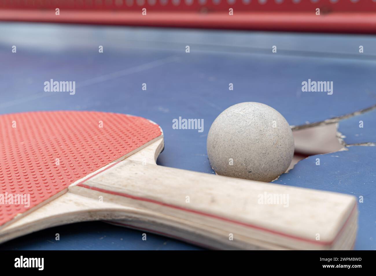 angle view pingpong ball and racket on a damaged table at horizontal composition Stock Photo
