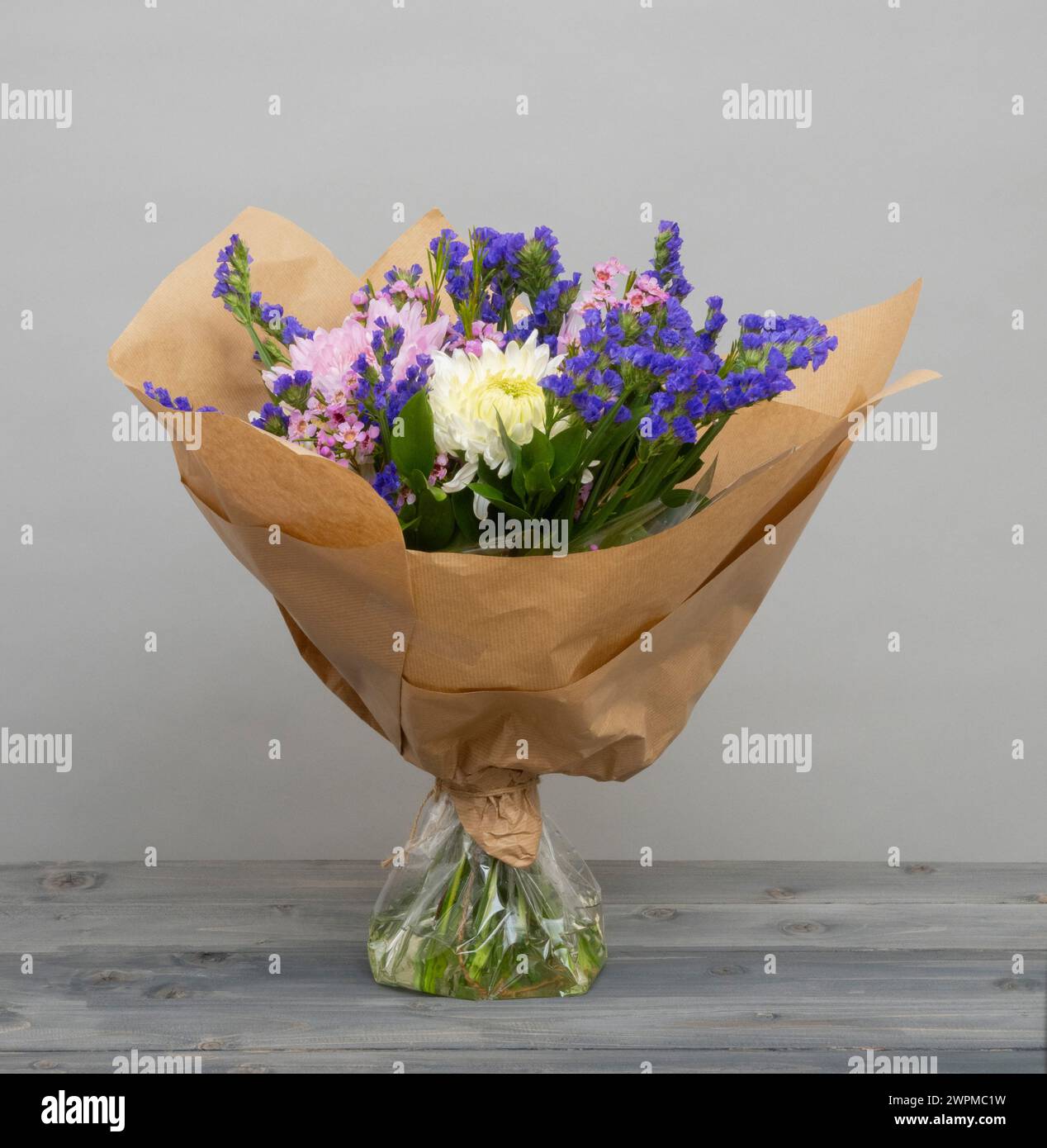 Hand-tied bouquet with water in cellophane for freshness, then wrapped in brown paper Stock Photo