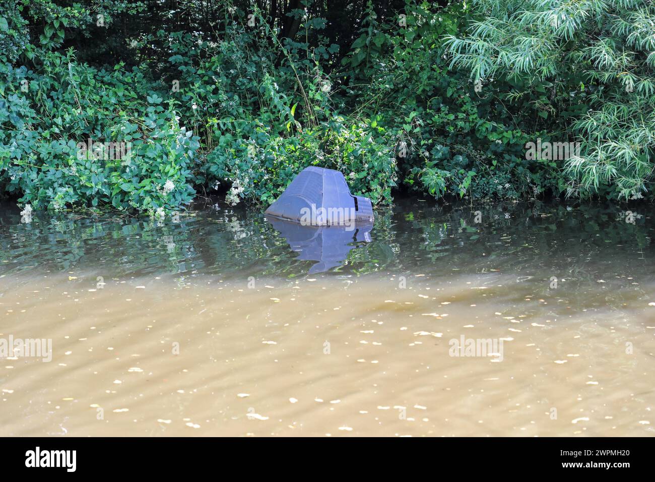 A dumped television set in the Trent and Mersey Canal, Stoke on Trent, Staffordshire, England, UK Stock Photo