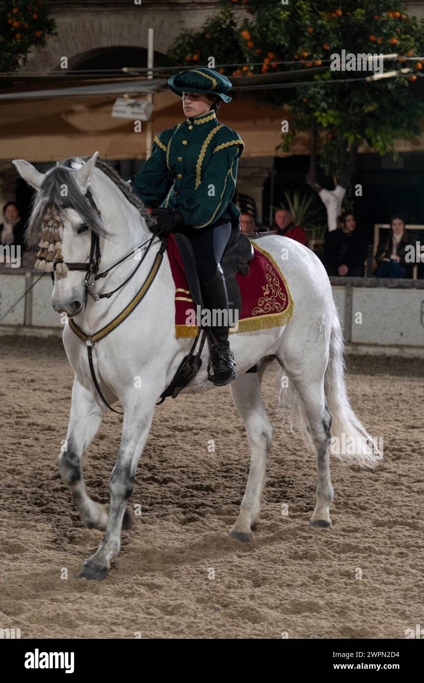 Las Caballerizas Reales de Cordoba (The Royal Stables of Cordoba)    A girl rider dressed in a green period uniform shows her horsemanship skills with Stock Photo