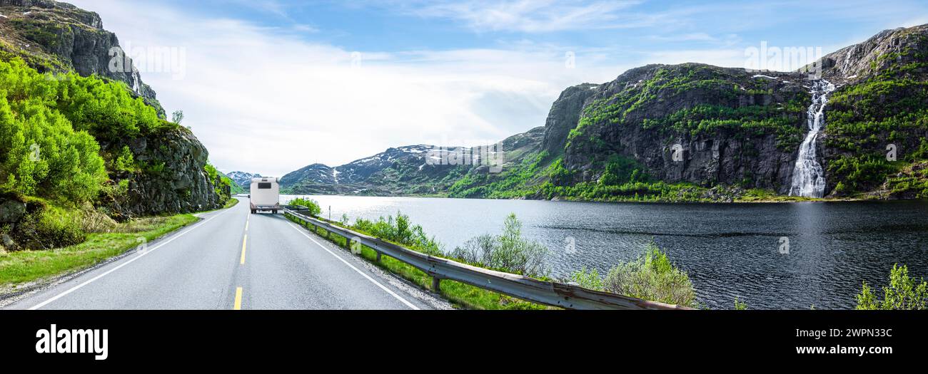 Camper on a shore road at a lake with a waterfall in Norway Stock Photo