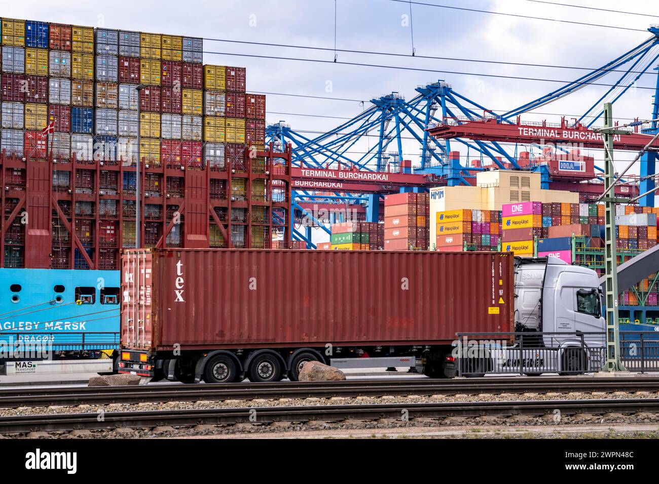 Port of Hamburg, Waltershofer Hafen, container ships, trucks bring and collect freight containers to and from HHLA Container Terminal Burchardkai, Ham Stock Photo