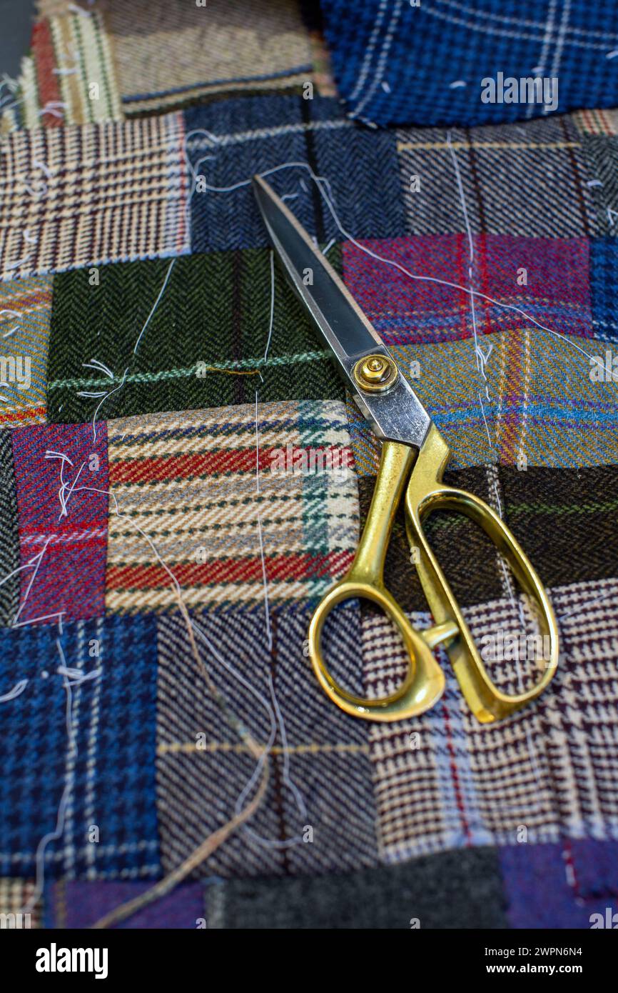 scissors and tweed fabric on tailor's bench Stock Photo