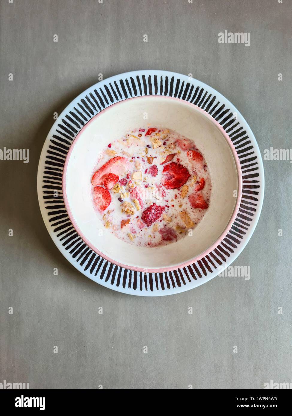Dried strawberries in muesli with milk in a bowl Stock Photo