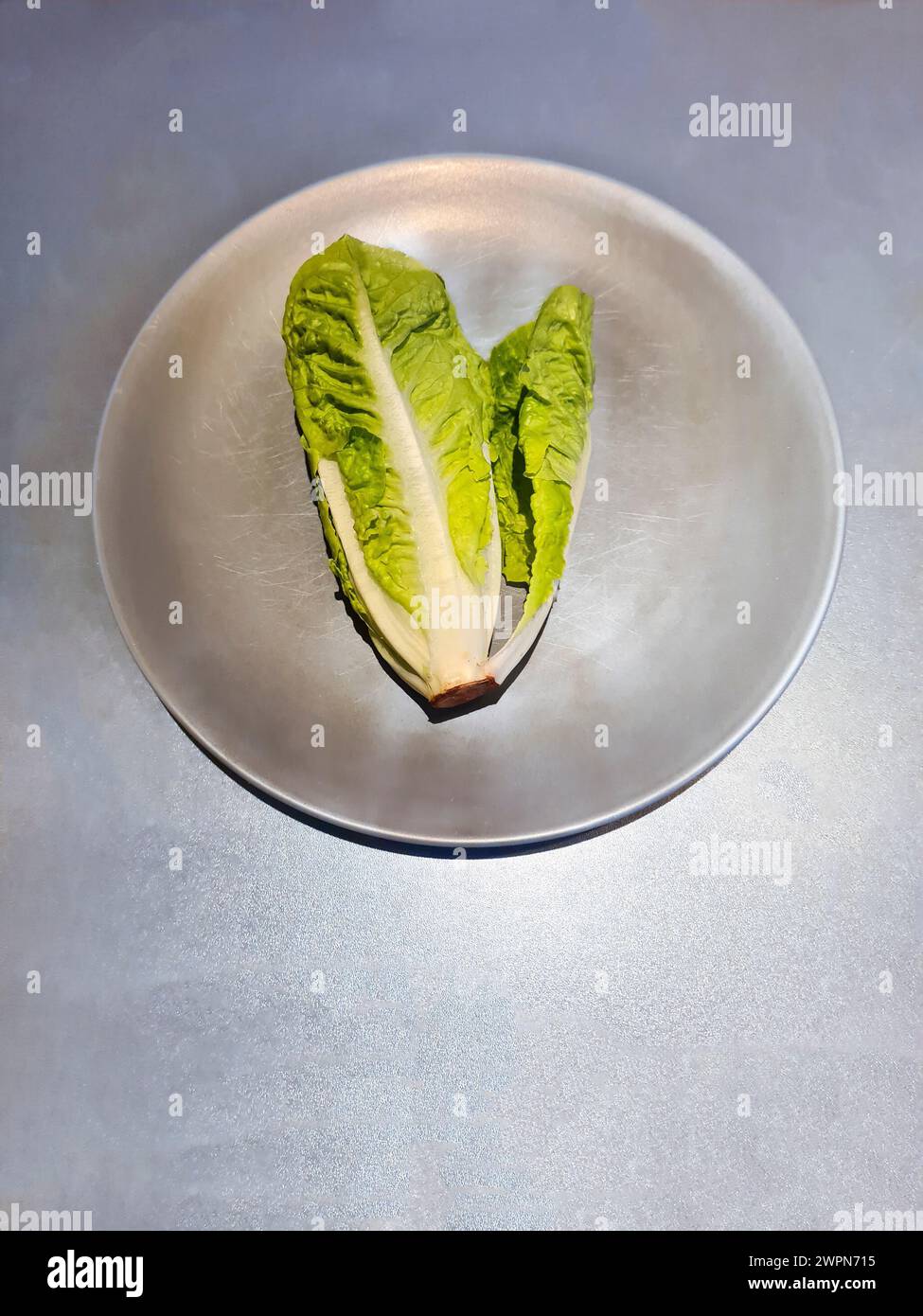 Lettuce heart, small romaine lettuce, whole green salad leaves on a plate Stock Photo