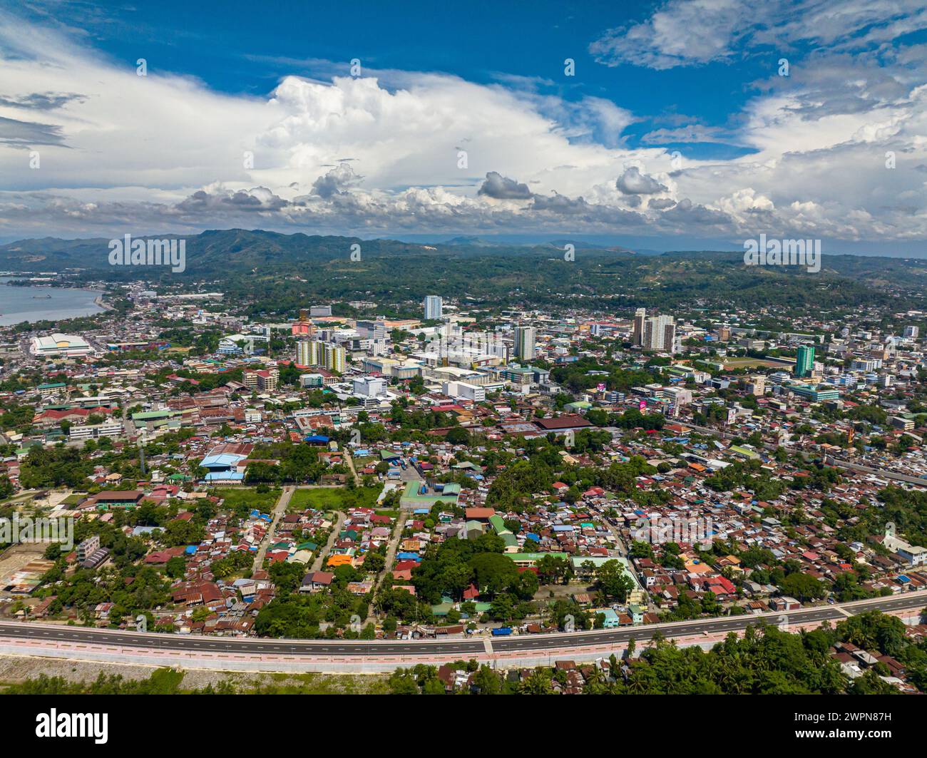 Cagayan de Oro with highway and modern buildings under blue sky and clouds. Northern Mindanao, Philippines. Stock Photo
