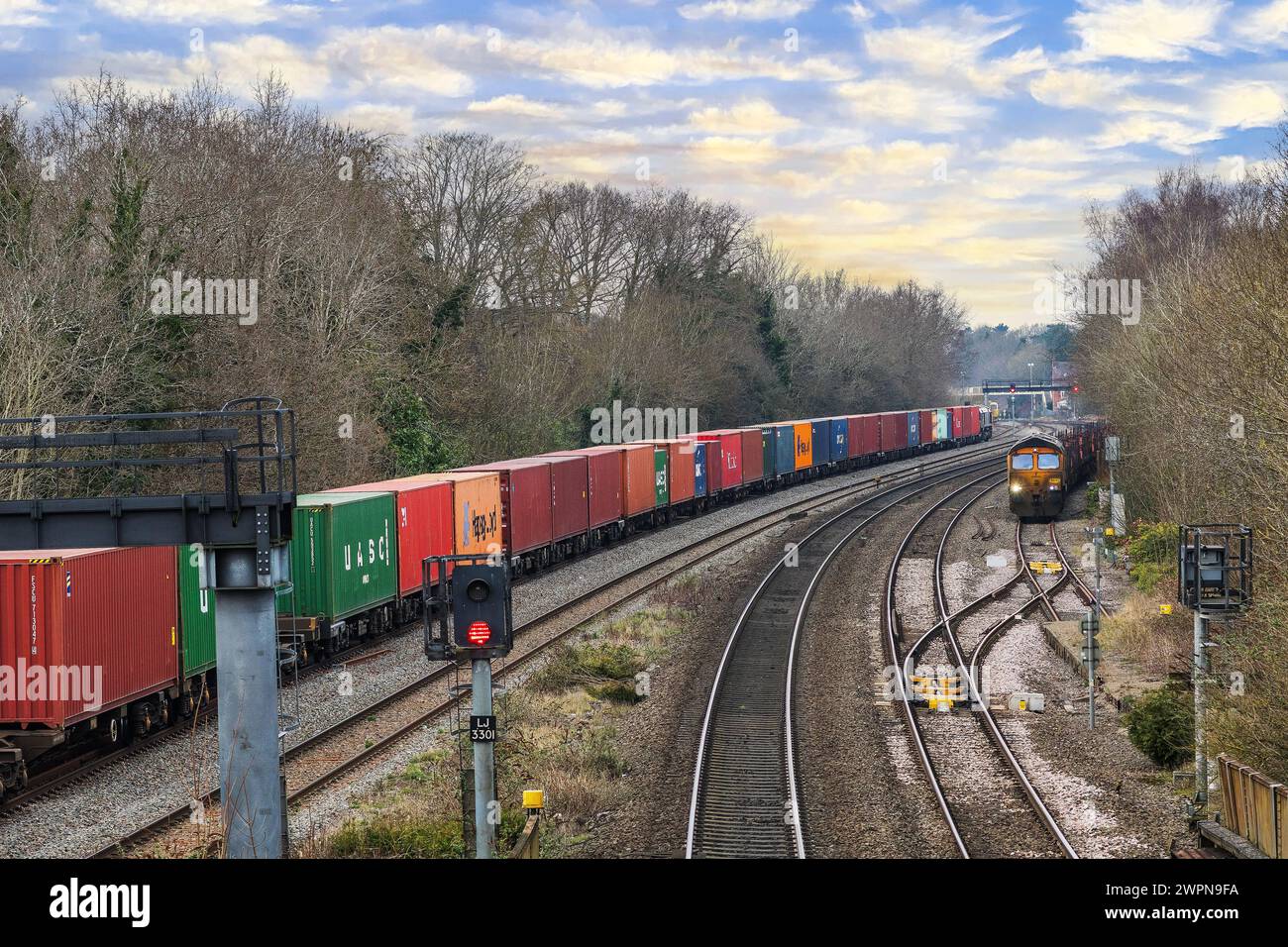 Afreight train is passing through Dorridge station west midlands England UK. Carrying goods containers imports exports. Stock Photo