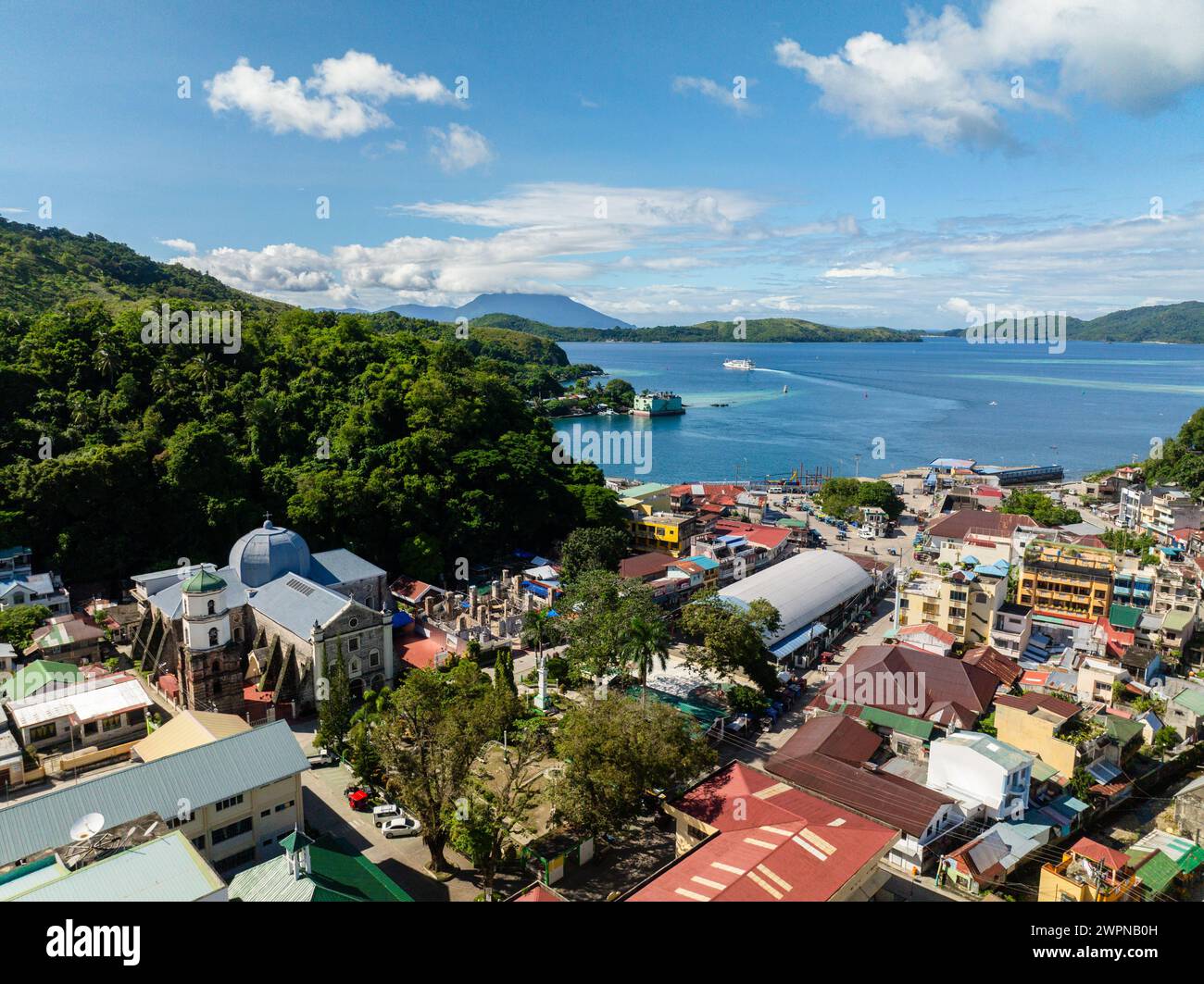 Aerial view of commercial buildings and streets in Romblon Island. Ferry over the blue sea. . Romblon, Philippines. Stock Photo
