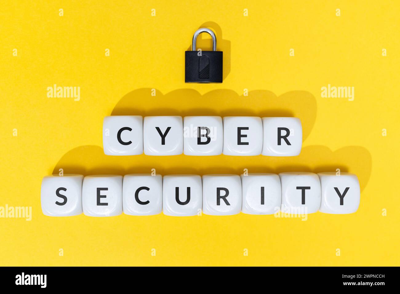 Cyber security concept. Text on blocks and padlock on yellow background Stock Photo