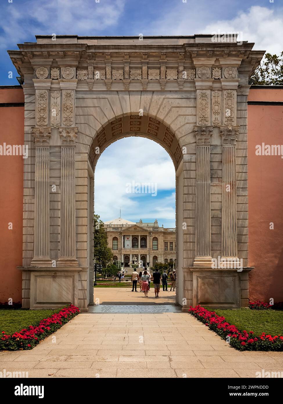 an inlaid marble arch leads the guest to the majestic gardens of the Dolmabahce Palace, located at the end of the path Stock Photo