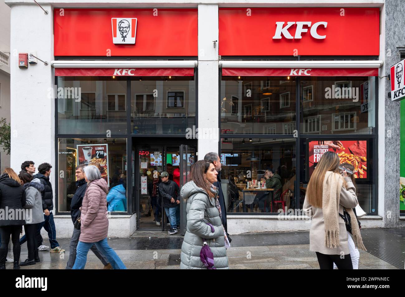 Madrid, Spain. 08th Mar, 2024. Pedestrians walk past the American fast food chicken restaurant chain, Kentucky Fried Chicken (KFC) and its logo in Spain. (Photo by Xavi Lopez/SOPA Images/Sipa USA) Credit: Sipa USA/Alamy Live News Stock Photo