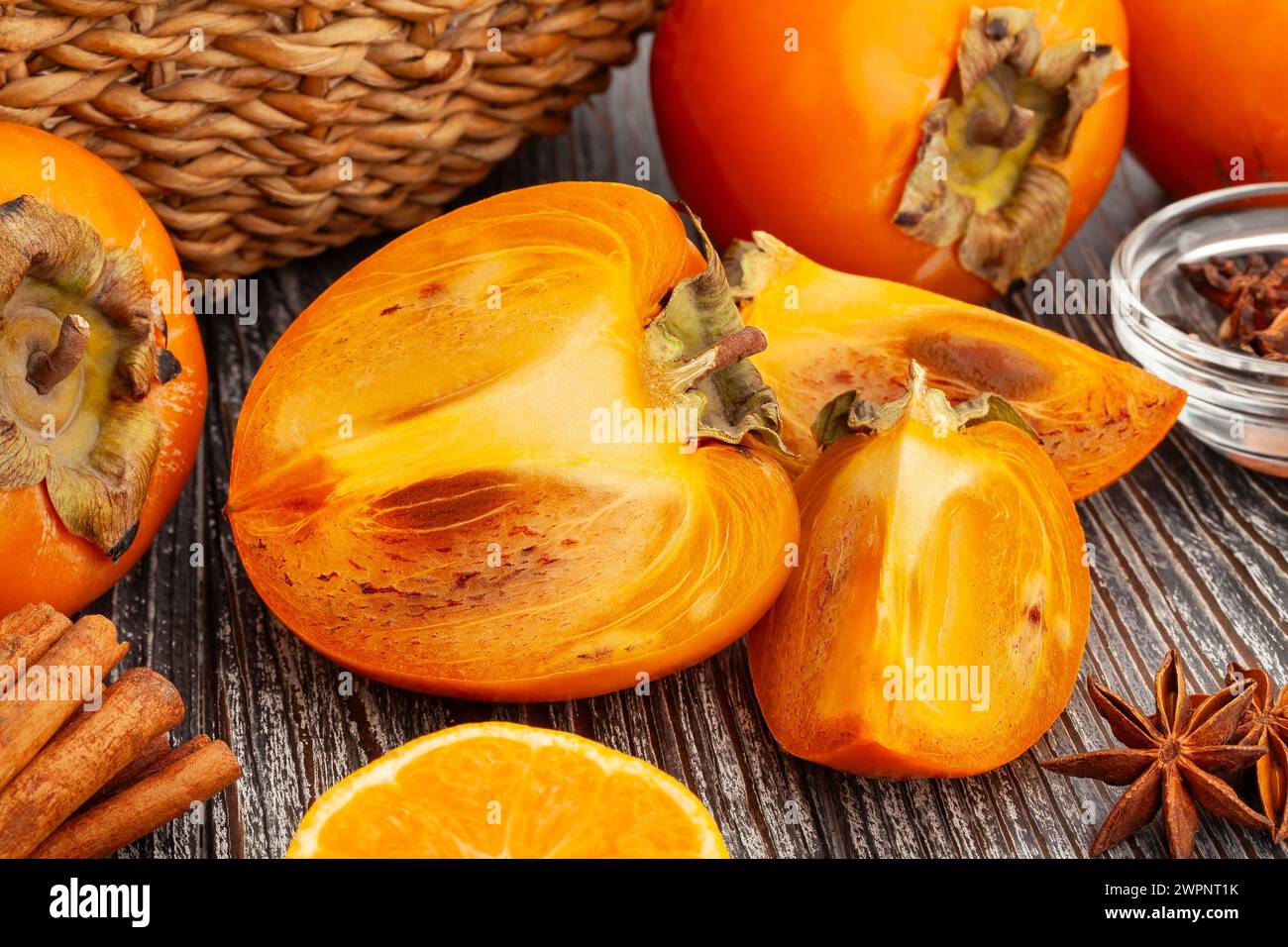 sliced persimmon on wood background Stock Photo