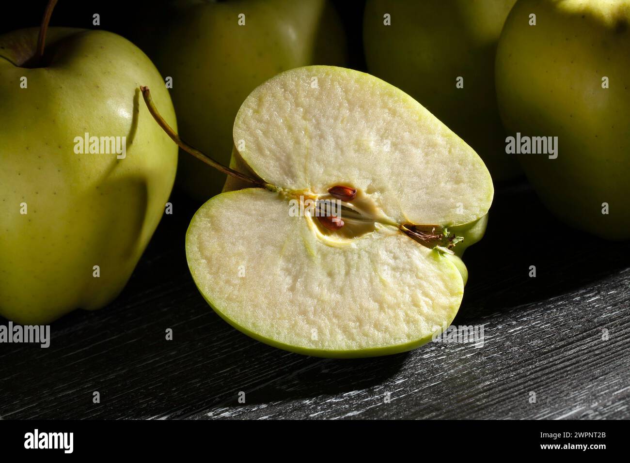 sliced apple on black wood background Stock Photo