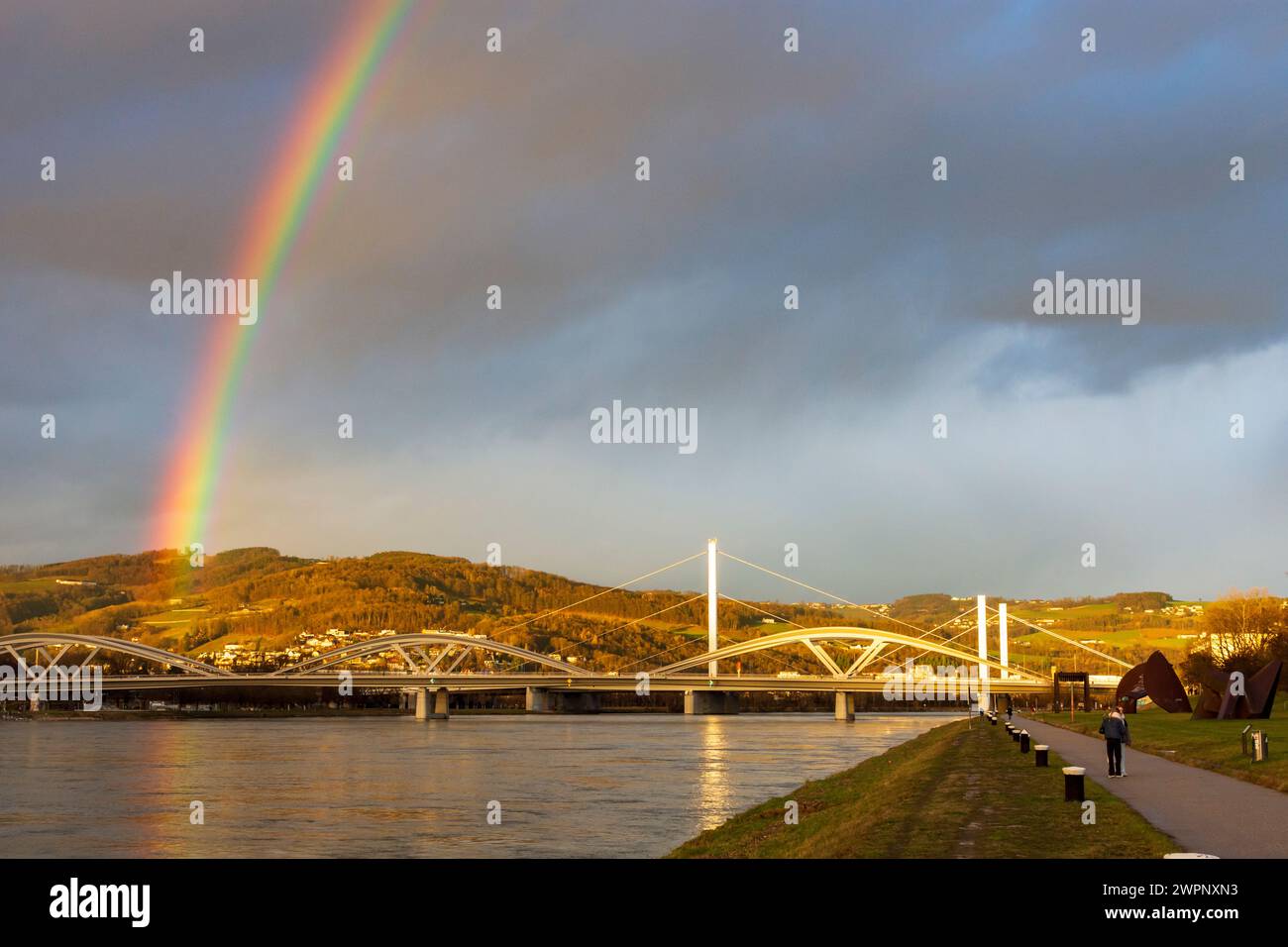 Linz, rainbow over river Donau (Danube), way at Donaulände, bridge Eisenbahnbrücke, bridge VOEST-Brücke (behind) in Zentralraum, Oberösterreich, Upper Austria, Austria Stock Photo
