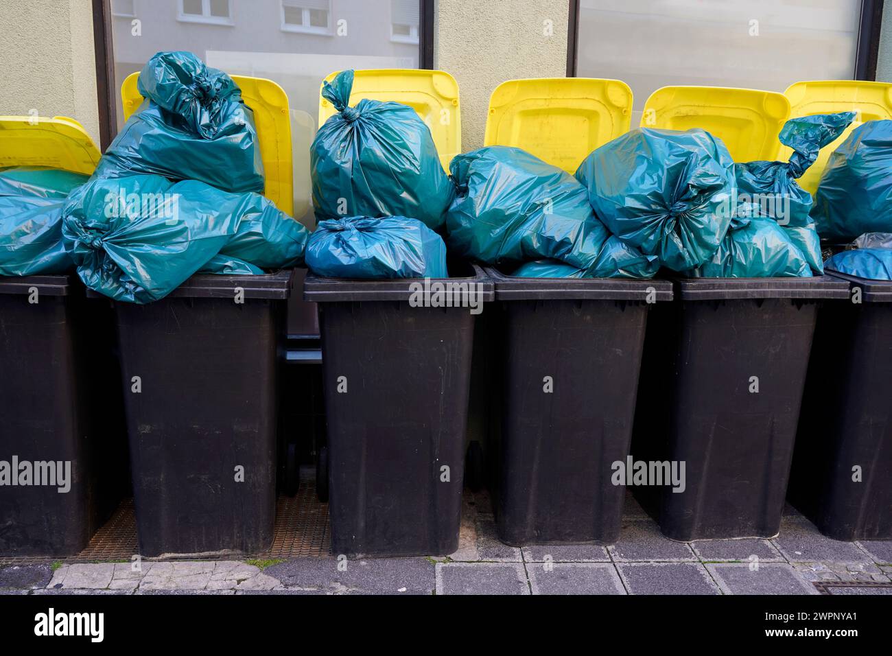 Germany, Bavaria, Nuremberg, garbage cans, next to each other, overfilled, blue garbage bags Stock Photo