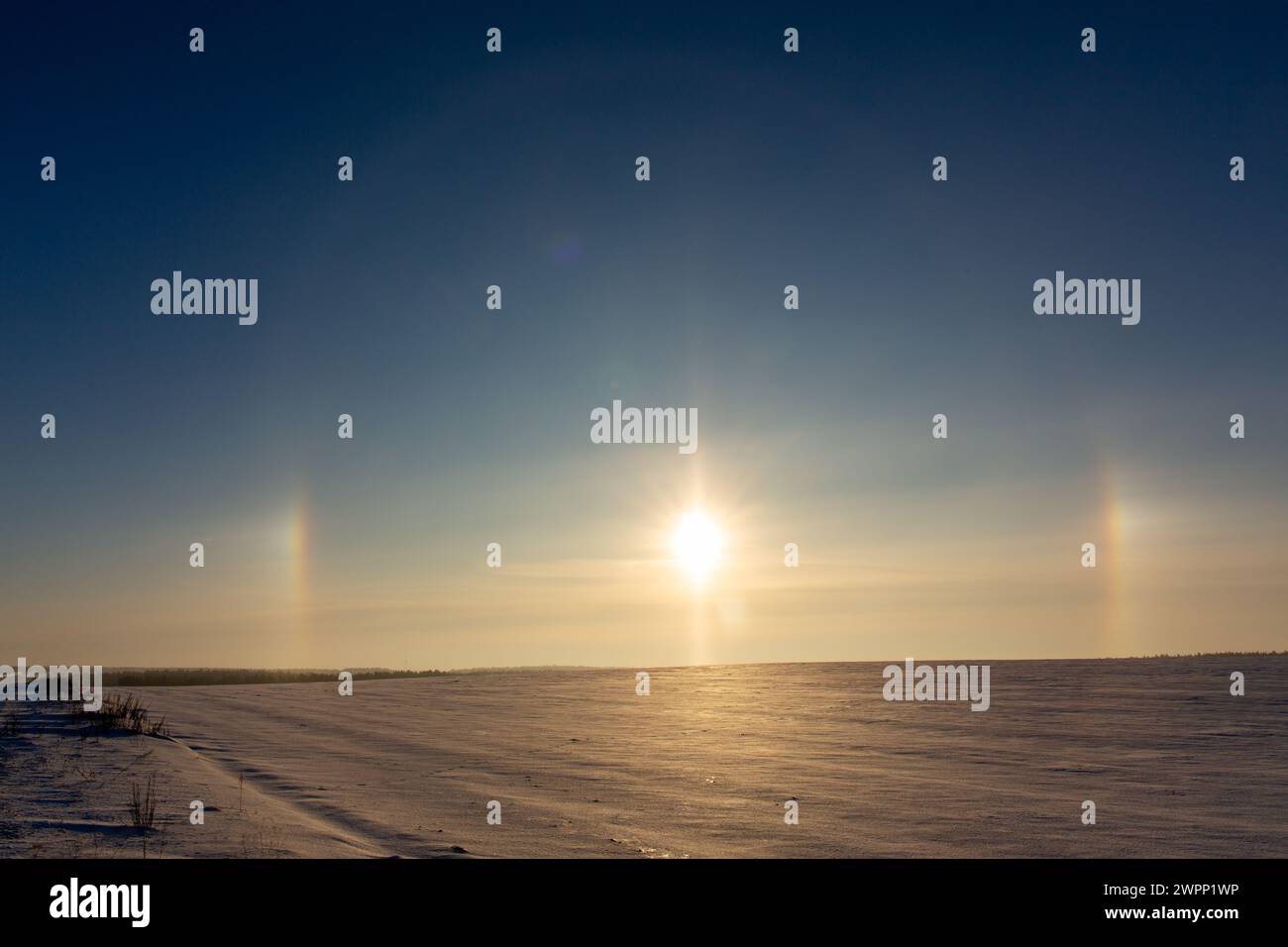 Winter landscape with circular halo phenomena around the sun in form of ...