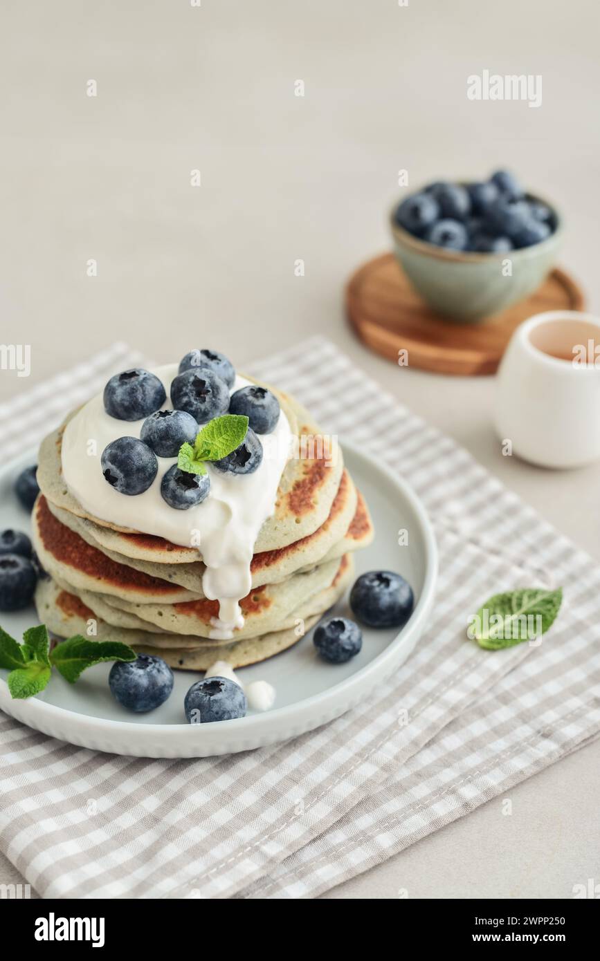 Plate blueberry pancakes with sour cream and coffee out in the background. Stock Photo