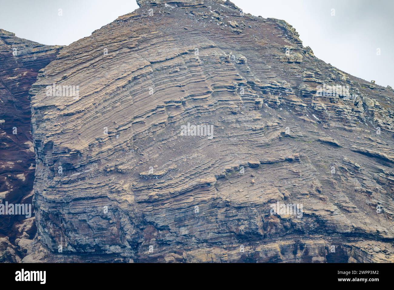 Layers of volcanic ash deposits form the cliff on the coast. Deception Island, Antarctica. Stock Photo