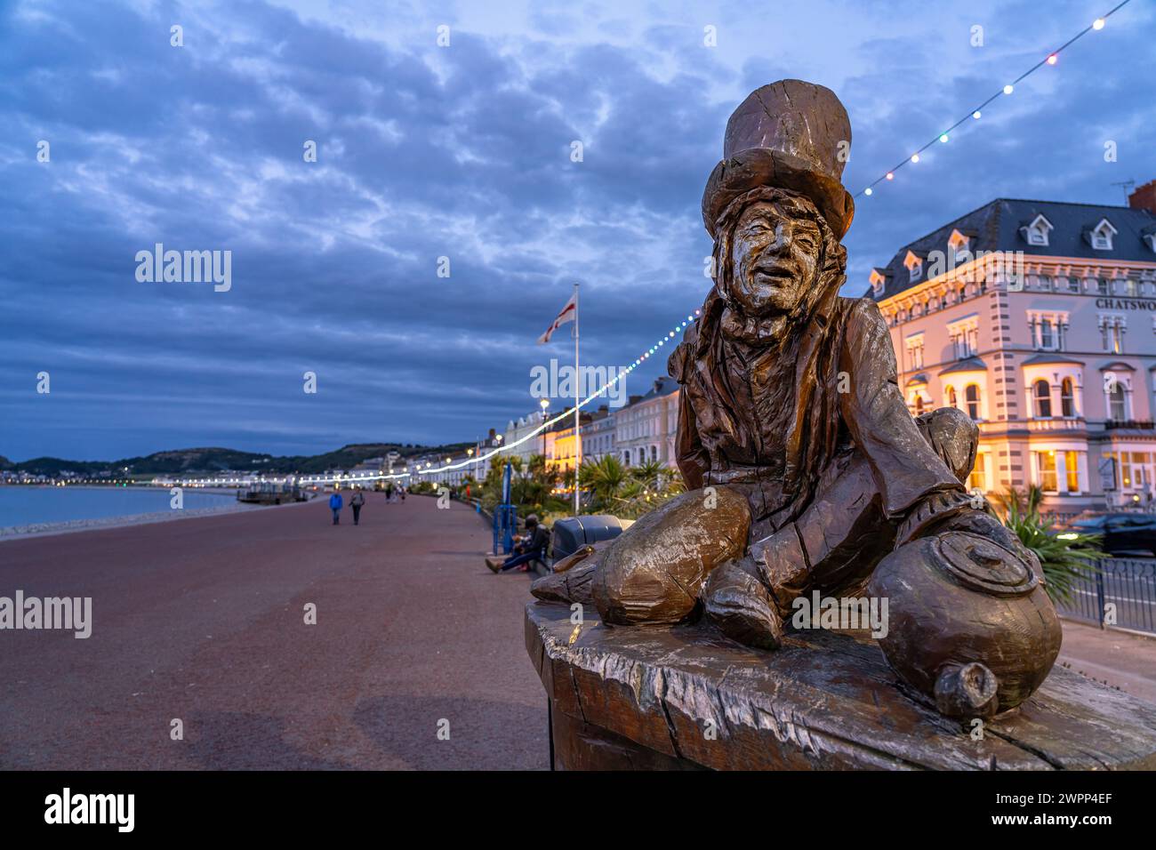 Sculpture of the Mad Hatter or The Mad Hatter from Alice in Wonderland on the promenade of the seaside resort of Llandudno at dusk, Wales, Great Britain, Europe Stock Photo