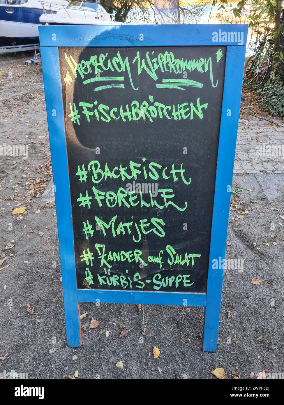 An advertising sign at Wannsee advertises fish sandwiches, fried fish, trout, matjes, pike-perch on salad and pumpkin soup in handwriting on its billboard Stock Photo