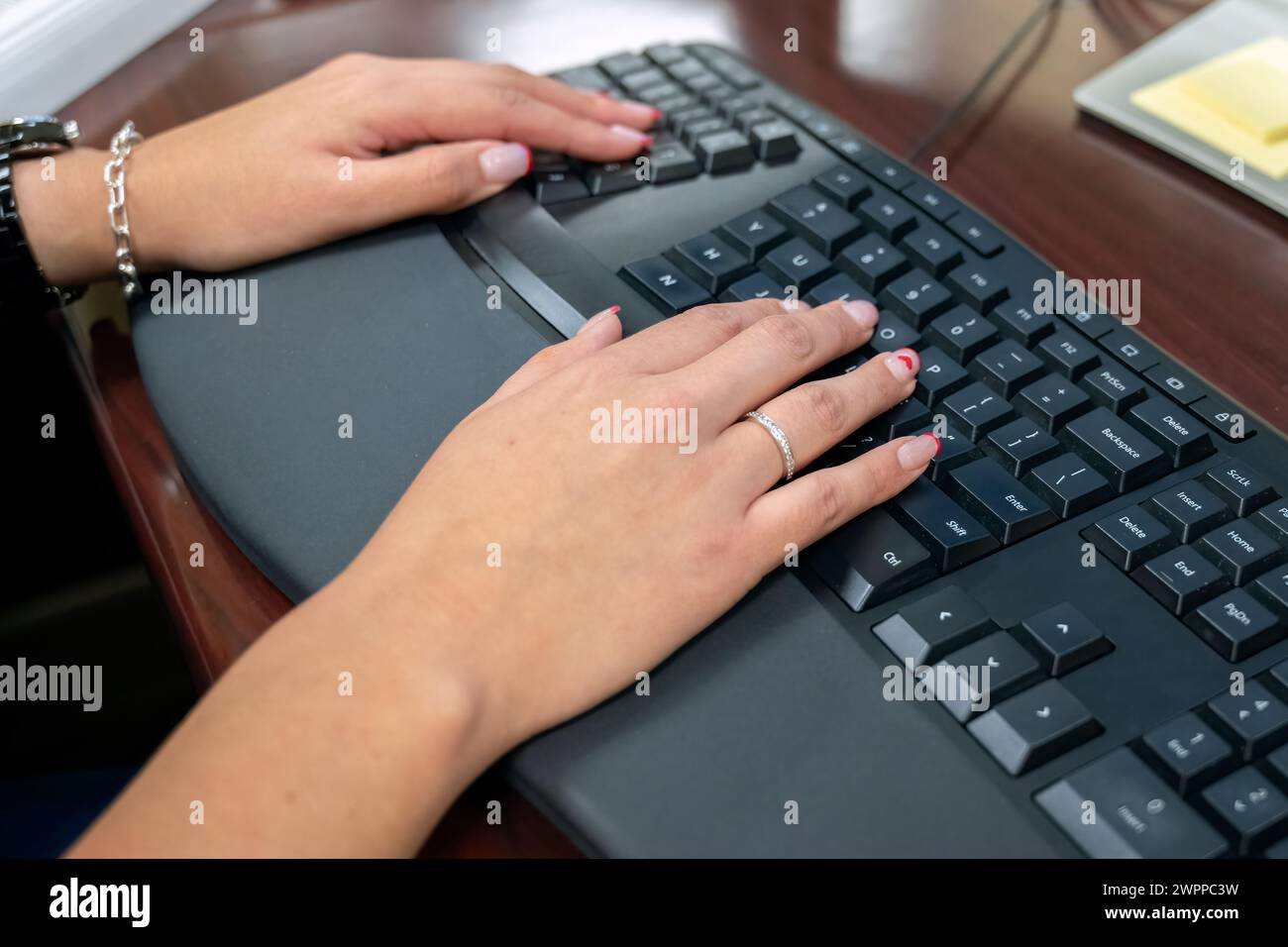 Feminine hands entering keystrokes on the keyboard for statistical data analysis. Stock Photo