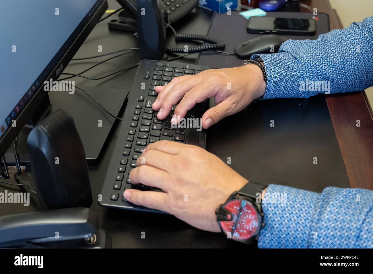 Masculine hands entering keystrokes on the keyboard for statistical data analysis. Stock Photo