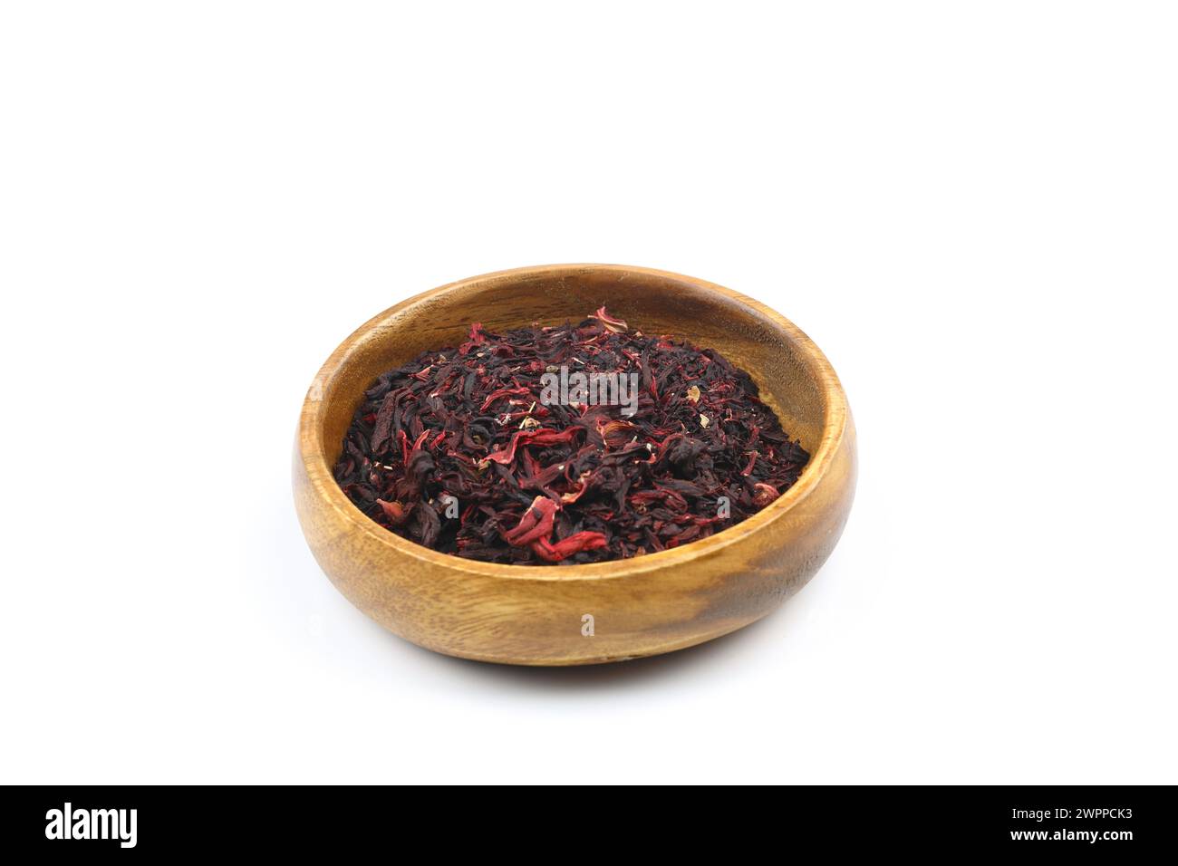 Karkade tea. Hibiscus tea leaves in wooden bowl isolated on white background. File contains clipping path. Top view. Stock Photo