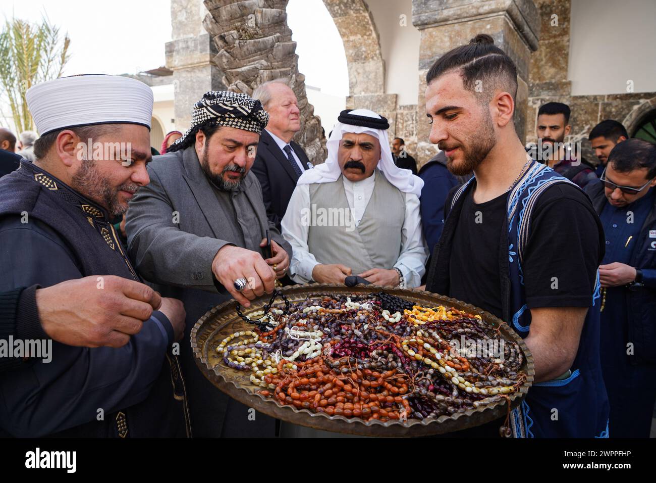 A young man distributes rosaries to people during the opening of Al-Masfi (Umayad) mosque in the old city of Mosul after completion of its restoration. The Umayad mosque also known Al-Masfi mosque is considered the oldest in Mosul, the second oldest mosque in Iraq, and the 5th oldest mosque in Islam. It dates back to the year 16 AH (637 AD). The mosque was damaged during the operations to liberate the city of Mosul from ISIS, and the mosque was reconstructed by the ALIPH organization in cooperation with LA GUILDE Association and Al-Tameer International Group, in cooperation with the Sunni Endo Stock Photo